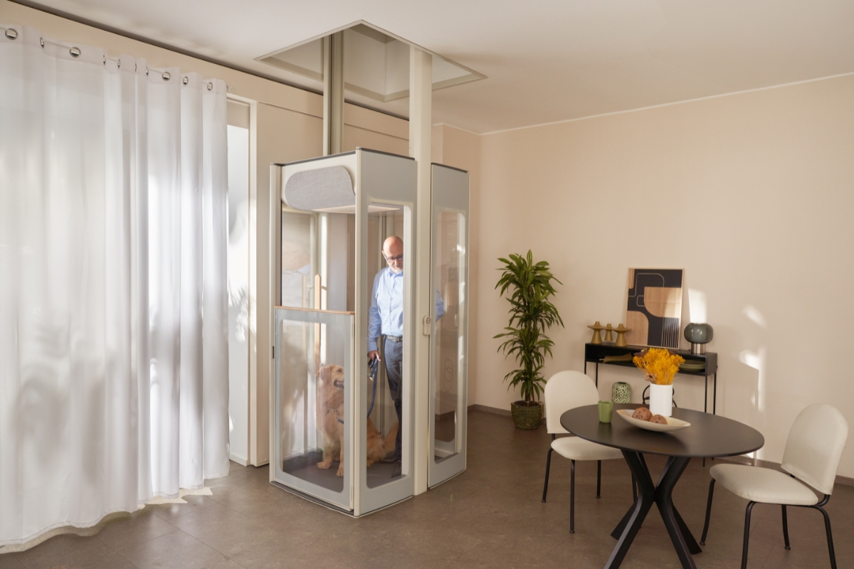 Ένας μεσήλικας με τον σκύλο του στον οικιακό ανελκυστήρα Uplifts της Stannah.