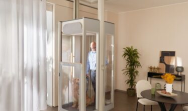 Ένας μεσήλικας άνδρας με τον σκύλο σε ανελκυστήρα Uplifts S3 εγκατεστημένο σε μοντέρνο σαλόνι.