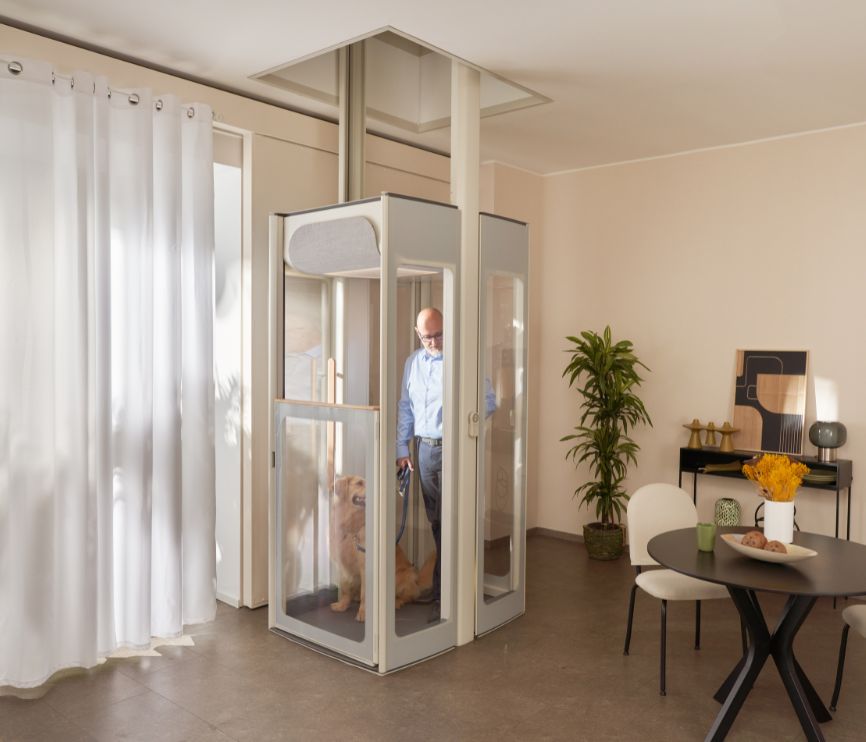 Ένας μεσήλικας άνδρας με τον σκύλο σε ανελκυστήρα Uplifts S3 εγκατεστημένο σε μοντέρνο σαλόνι.