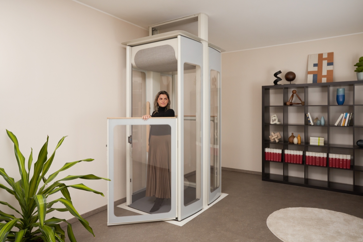 Γυναίκα μέσα σε έναν οικιακό ανελκυστήρα της Stannah Uplifts με ανοιχτή πόρτα, δείχνοντας τις τις διαφανείς πλευρές και την εξοικονόμηση χώρου. 